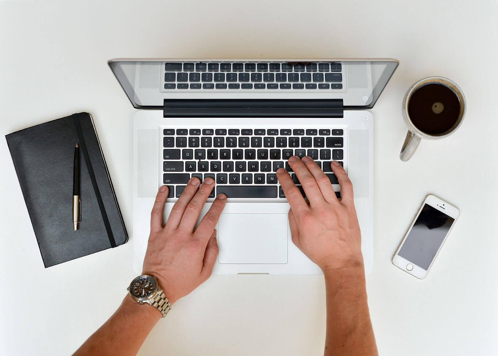 Hands typing on a laptop