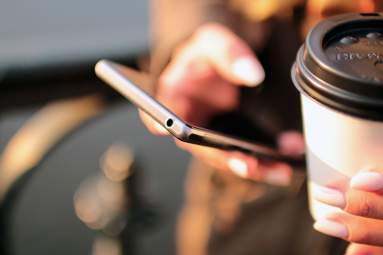 A mobile phone and coffee to go