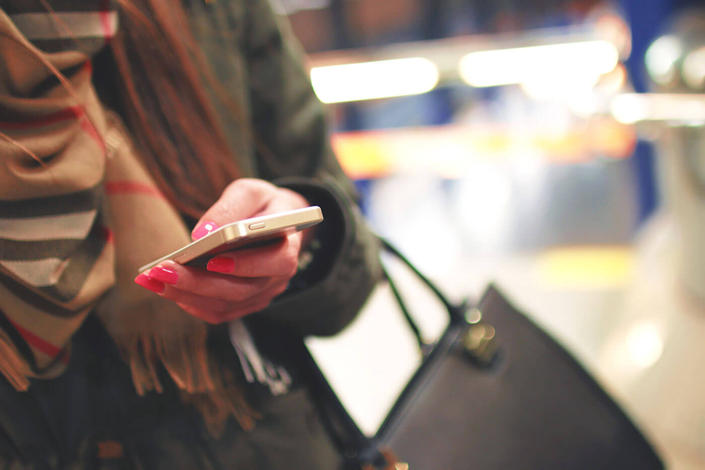 A woman with a purse and mobile phone in hand