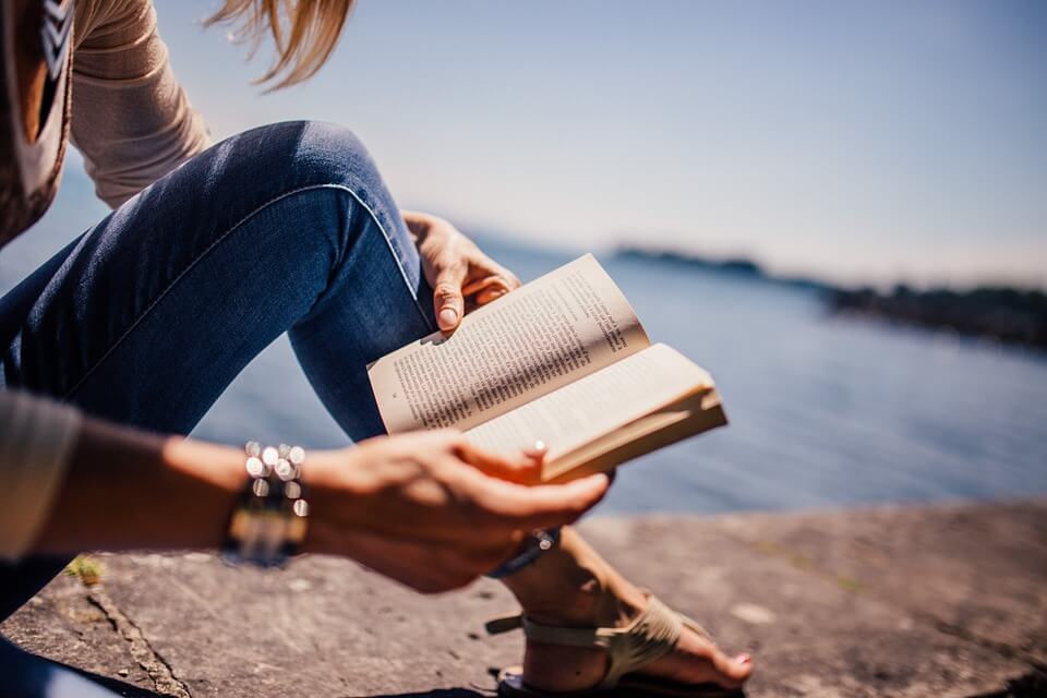 Woman reading next to water