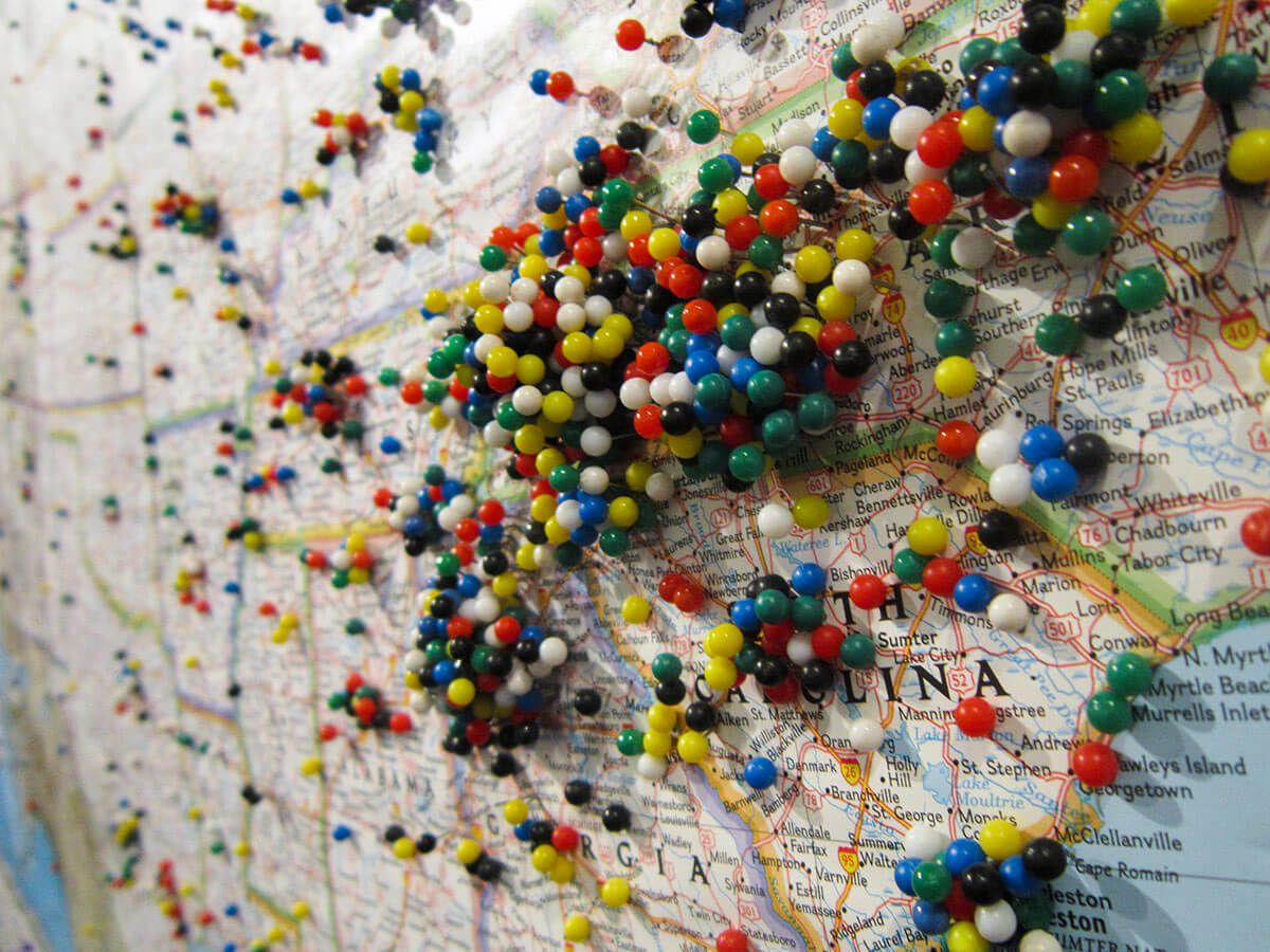 Multi-colored pins stuck in a map of the United States