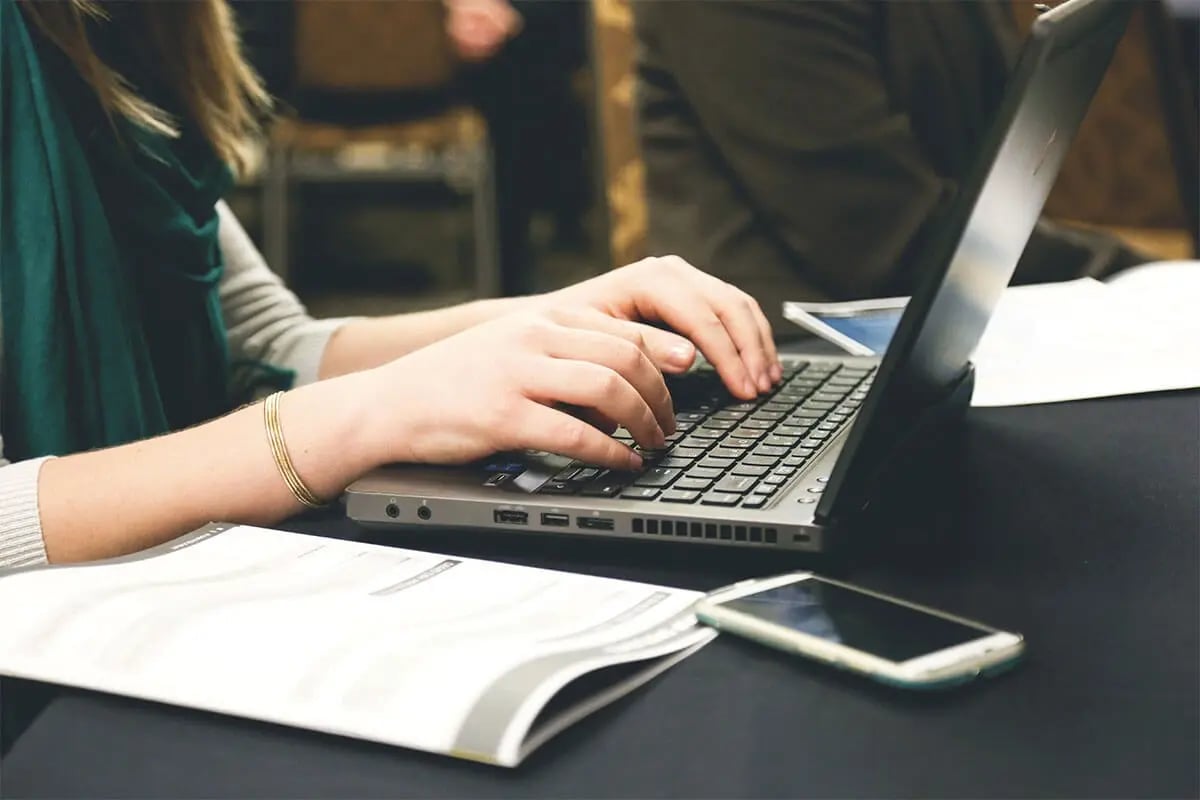 Woman's hands typing on a laptop